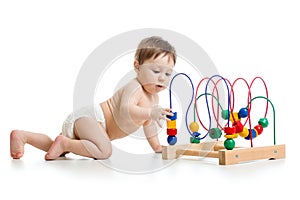 Crawling baby in a diaper plays with educational toy  on white