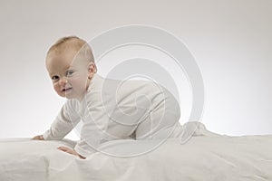 Crawling cute baby boy on the white background. Studio shot