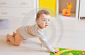 Crawling funny baby boy indoors at home