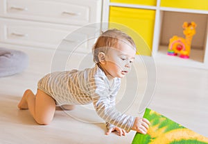 Crawling funny baby boy indoors at home