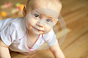 A crawling funny baby indoors at home play with block