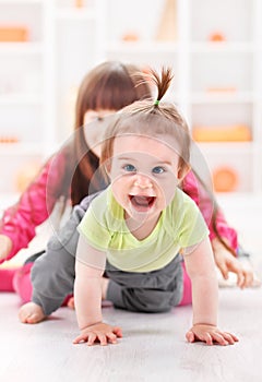 Crawling pigtailed toddler girl playing photo