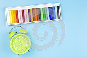 Crayon and green clock morning on blue background pastel style w