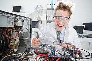 Crazed computer engineer holding hammer over console