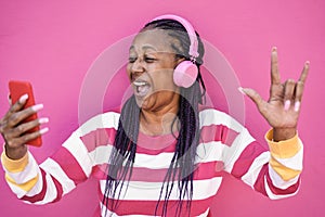 Crazy african senior woman listening music on mobile phone app - Focus on face