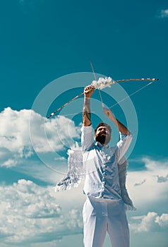 Crazy angel cupid valentin with bow arrow ready to shoot. Funny bearded man with feathers wings of Cupid Valentines Day