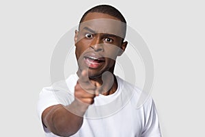 Crazy angry African American man pointing finger at camera