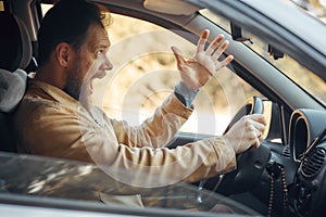 Crazy Angry Man Annoyed While Driving a Car. Mad Agrressive Driver Screaming Irritated with Traffic