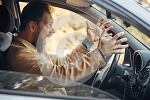 Crazy Angry Man Annoyed While Driving a Car. Mad Agrressive Driver Screaming Irritated with Traffic