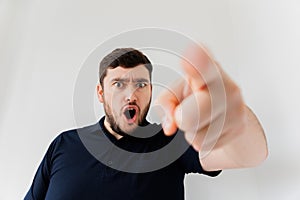 Crazy bearded man screaming looking at camera and pointing to camera,