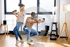 Crazy beautiful caucasian couple playing video games in virtual reality glasses