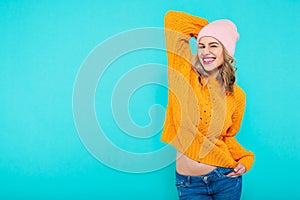 Crazy beautiful trendy girl with cheeky smile in colorful clothes and pink beanie hat. Attractive cool young woman portrait.