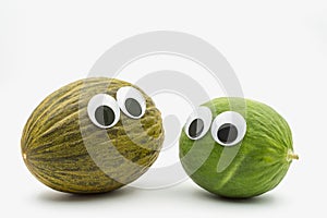 Crazy brown and green melon with googly eyes on white background