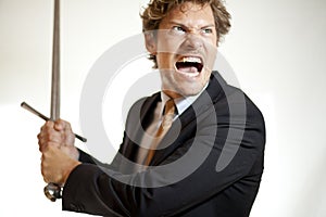 Crazy businessman attacking with a sword