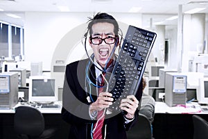 Crazy businessman hold keyboard at office