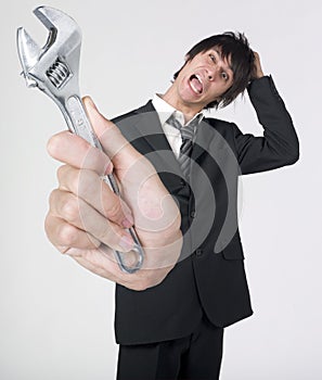 Crazy businessman holding wrench