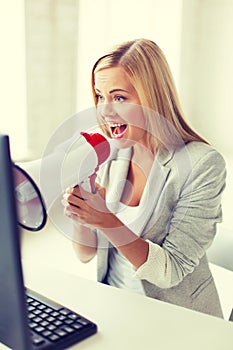 Crazy businesswoman shouting in megaphone