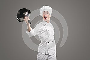 Crazy chef screaming loudly with raised pan