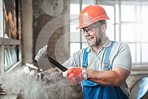 Crazy contractor strikes with a hammer, screaming and smiling