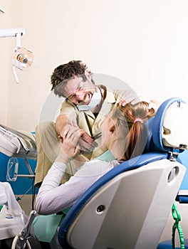 Crazy dentist treats teeth of the unfortunate patient. The patient is terrified.