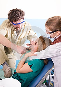 Crazy dentist treats teeth of the unfortunate patient. The patient is terrified.