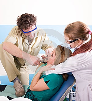 Crazy dentist treats teeth of the unfortunate patient. The patient is terrified.