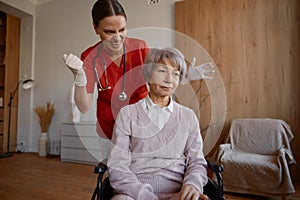 Crazy doctor making shot for old woman in wheelchair comic humorous photo