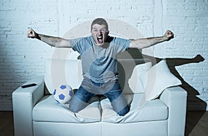 Crazy football fan watching tv soccer match alone screaming happy celebrating goal