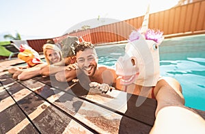 Crazy friends selfie doing pool party wearing bizarre mask - Young people having fun celebrating summer in tropical resort