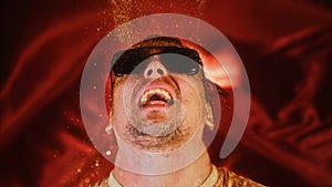 Crazy fun man sprinkles himself with sparkle particles. Fun photo funny face, tongue out. Comical funny portrait guy in