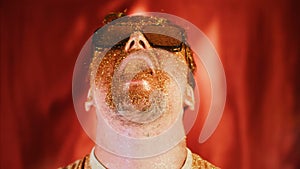Crazy fun positive face man in gold glitter. Comical photo shake head funny person. Pouring powder from open mouth