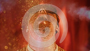 Crazy fun positive face man in gold glitter. Comical photo shake head funny person. Pouring powder from open mouth