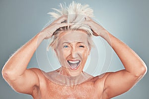 Crazy, funny and senior woman with hair problem or style issue on a grey studio background. Damage, bad and messy of