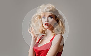 Crazy furious young pin up woman standing over gray background. Face expressions. Funny woman face.