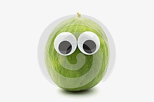 Crazy green melon with googly eyes on white background