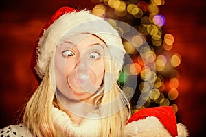 Crazy grimace. Blow Bubbles with Gum. Only fun on my mind. Girl Santa claus making big bubble with gum. Funny face close