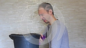 Crazy guy disinfects the trash bin with toilet water.