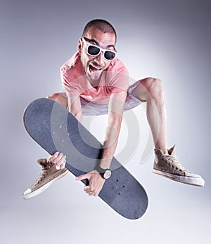 Crazy guy jumping with a skateboard making funny faces