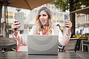 Crazy happy girl use phone, tablet and laptop simultaneously