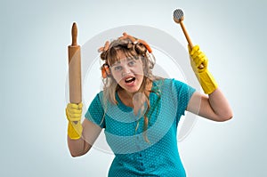 Crazy housewife with kitchen roller and meat hammer