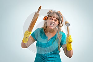 Crazy housewife with kitchen roller and meat hammer