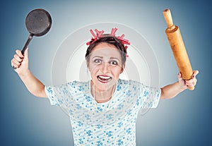 Crazy housewife with rolling pin and pan