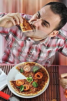 Crazy hungry man eating pizza