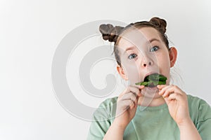 Crazy little girl stuffing spinach leaves into her mouth. Fun, wholesome food.