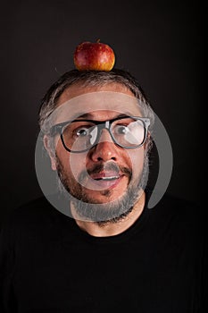 Crazy looking grumpy old man with grey beard and big nerd glasses with apple