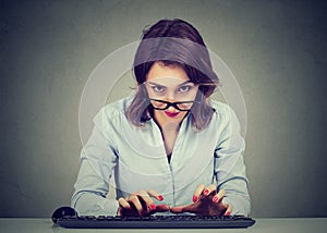 Crazy looking nerdy young woman typing on the keyboard wondering what to reply