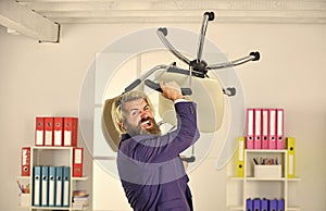 Crazy or mad. Hipster man angry with office chair. Get out of my office. Throw out chair. Businessman standing in office