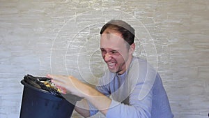 Crazy man delves into the bin that stinks.