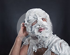 Crazy man with face completely in shaving foam photo