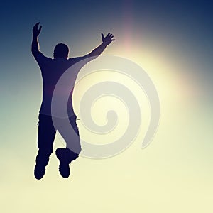 Crazy man is flying over Sun on blue sky background.